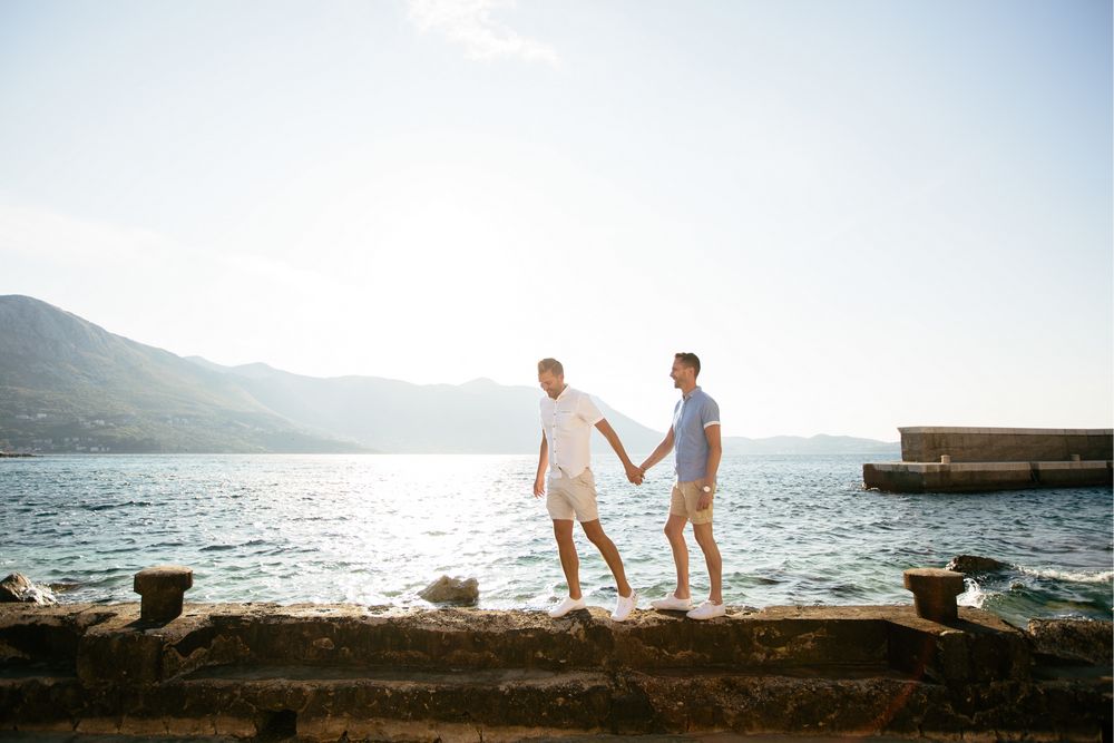 A gorgeous couple walking by the sea near Dubrovnik. Gay wedding in Dubrovnik. 